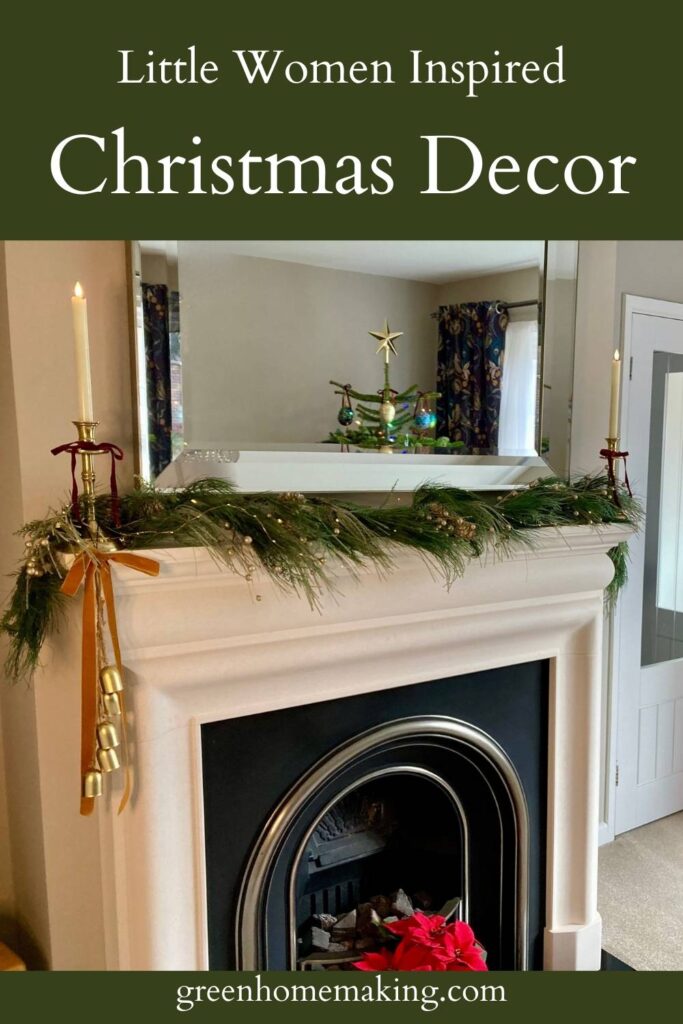 Little Women Inspired Christmas Decor - fireplace displaying green garland, gold candlesticks, velvet bow hanging on the left hand side with gold bells attached. There is a mirror above the fireplace reflecting a Christmas tree.