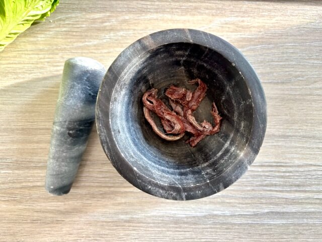 Anchovy fillets in pestle and mortar