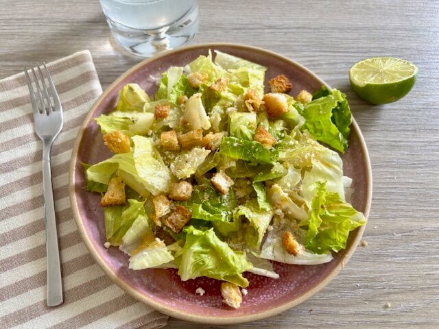 Caesar salad on pink plate