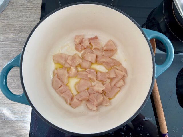Raw diced chicken in pan