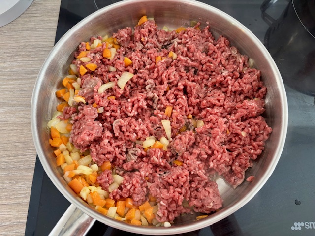 Adding the beef mince to the pan.