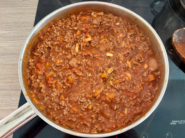 Adding the chopped tomatoes to the Bolognese sauce