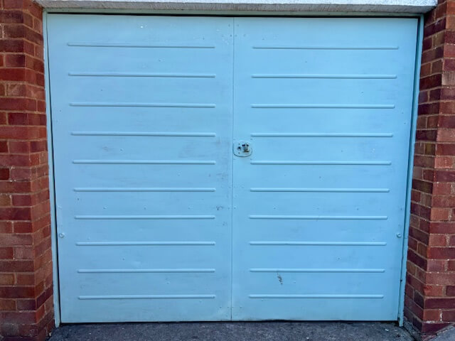 Before shot - light blue garage door that's quite scruffy looking