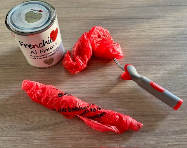 Tin of Frenchic Al Fresco paint next to brush and mini roller wrapped in plastic bags