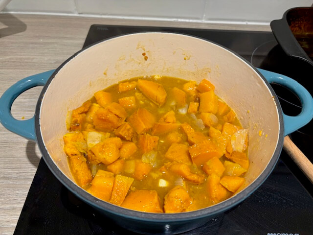 Adding the stock to the pan containing the other ingredients.
