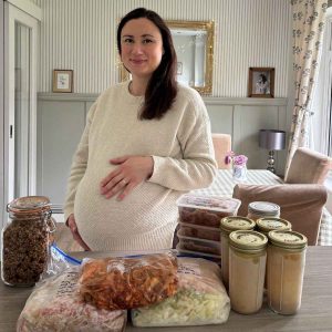Author of Green Homemaking stood at kitchen counter with her Postpartum Meal Prep