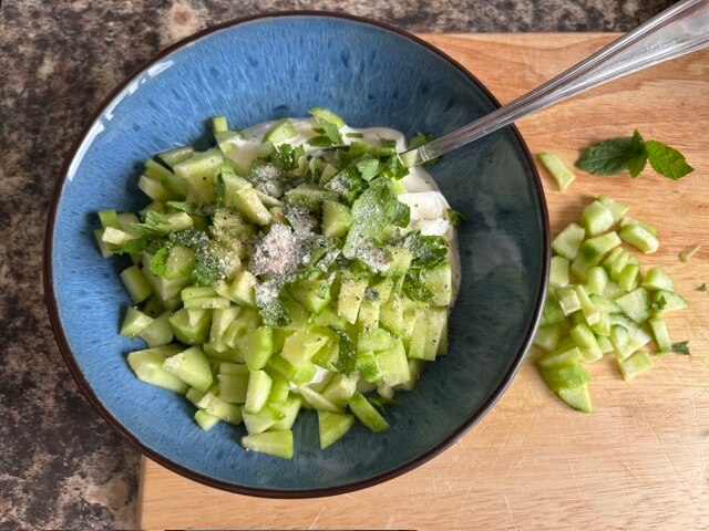 Tzatziki ingredients in blue bowl ready for mixing